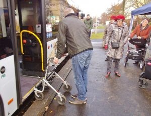 Der Mobilitätstrainer steht mit dem Rollator direkt vor der Tür des Busses